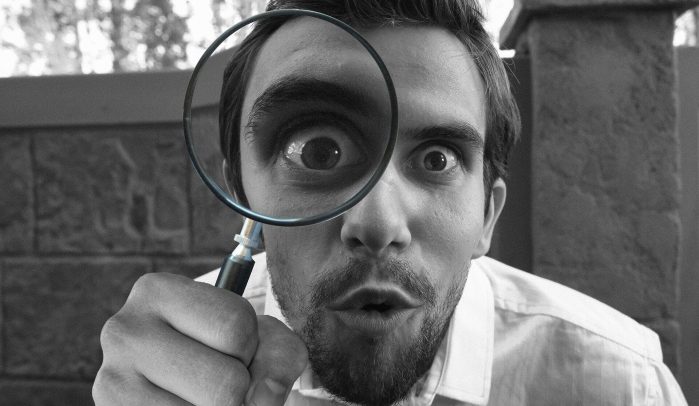 Man-looking-at-the-camera-through-a-magnifying-glass