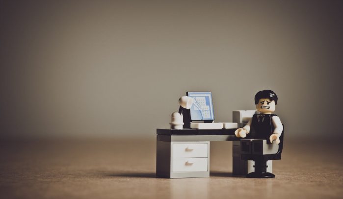Lego-businessman-with-despairing-expression-sitting-at-computer