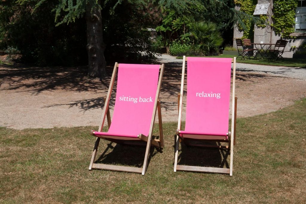 Two-pink-deckchairs-on-lawn