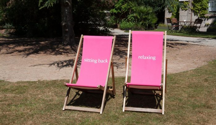 Two-pink-deckchairs-on-lawn