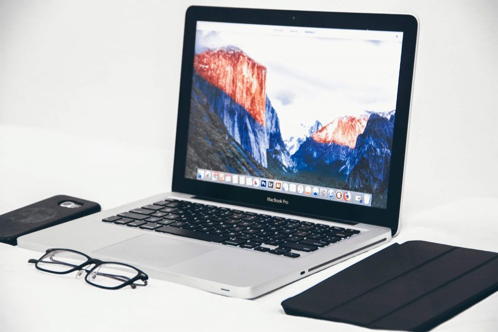 Desktop-with-laptop-iPad-iPhone-and-glasses