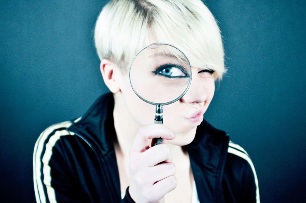 Woman-with-short-blond-hair-looking-through-a-magnifying-glass