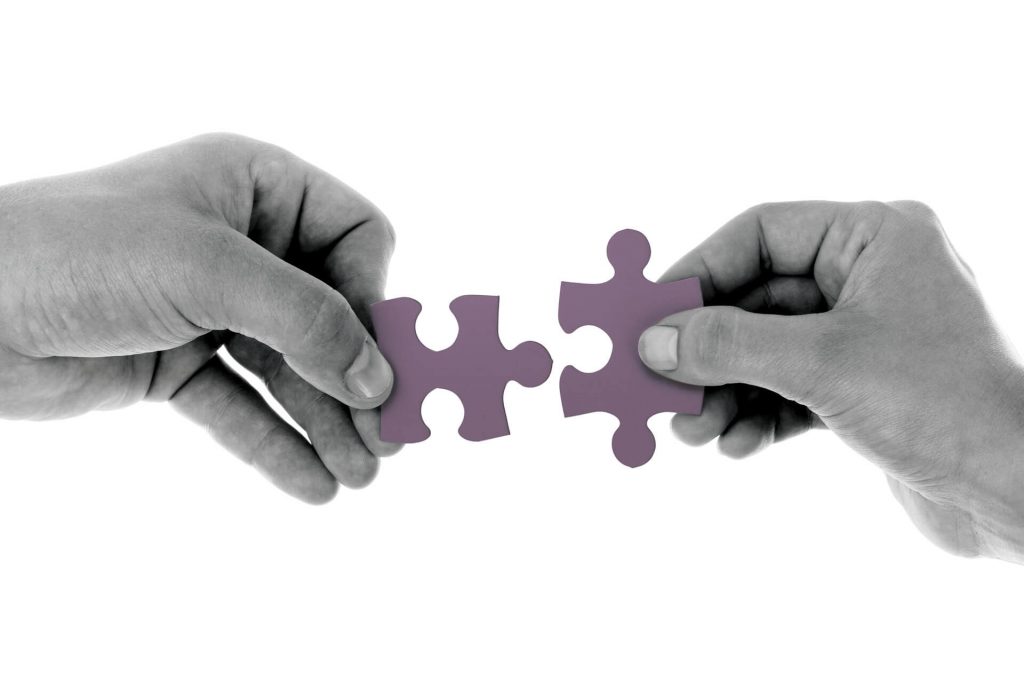 Two-hands-bringing-together-fitting-jigsaw-pieces
