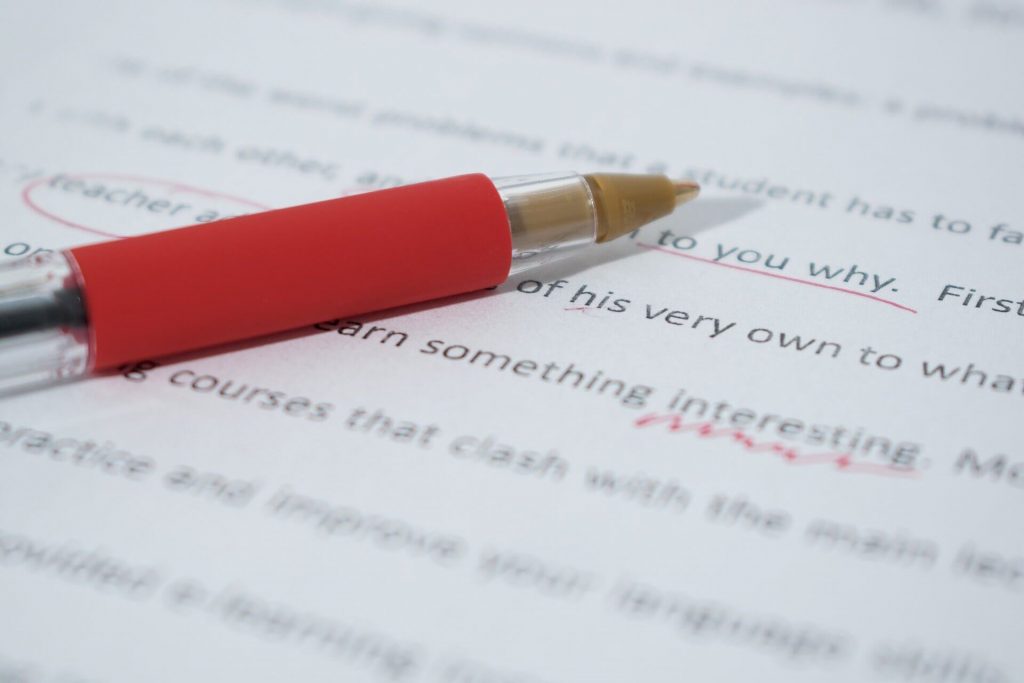 Red-pen-laying-on-page-of-corrected-text