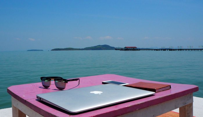 Pink-wooden-desk-with-laptop-by-the-sea-in-Thailand