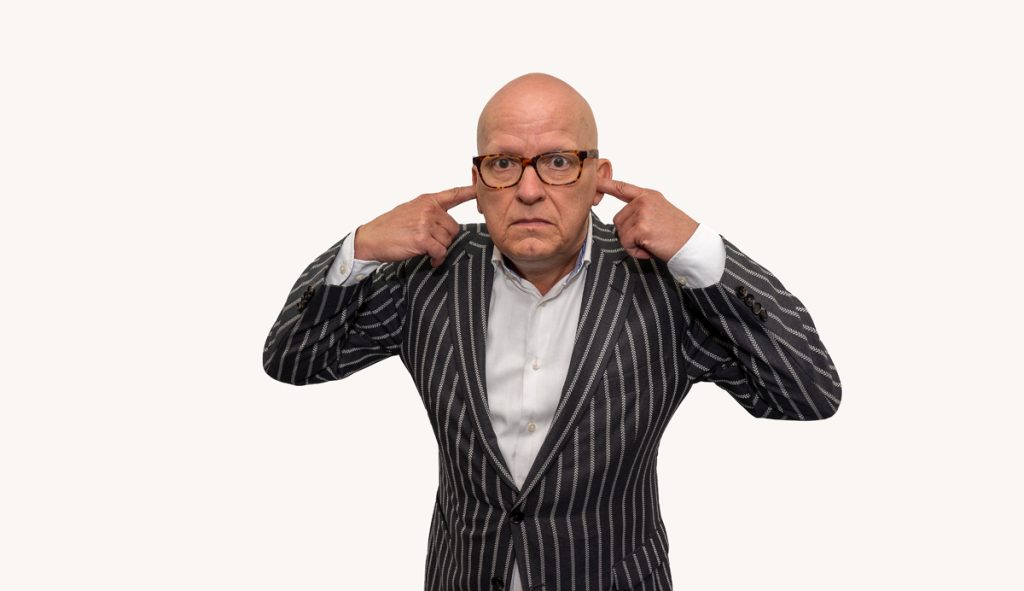 Man-in-black-framed-glasses-with-his-fingers-in-his-ears