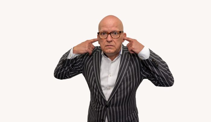 Man-in-black-framed-glasses-with-his-fingers-in-his-ears