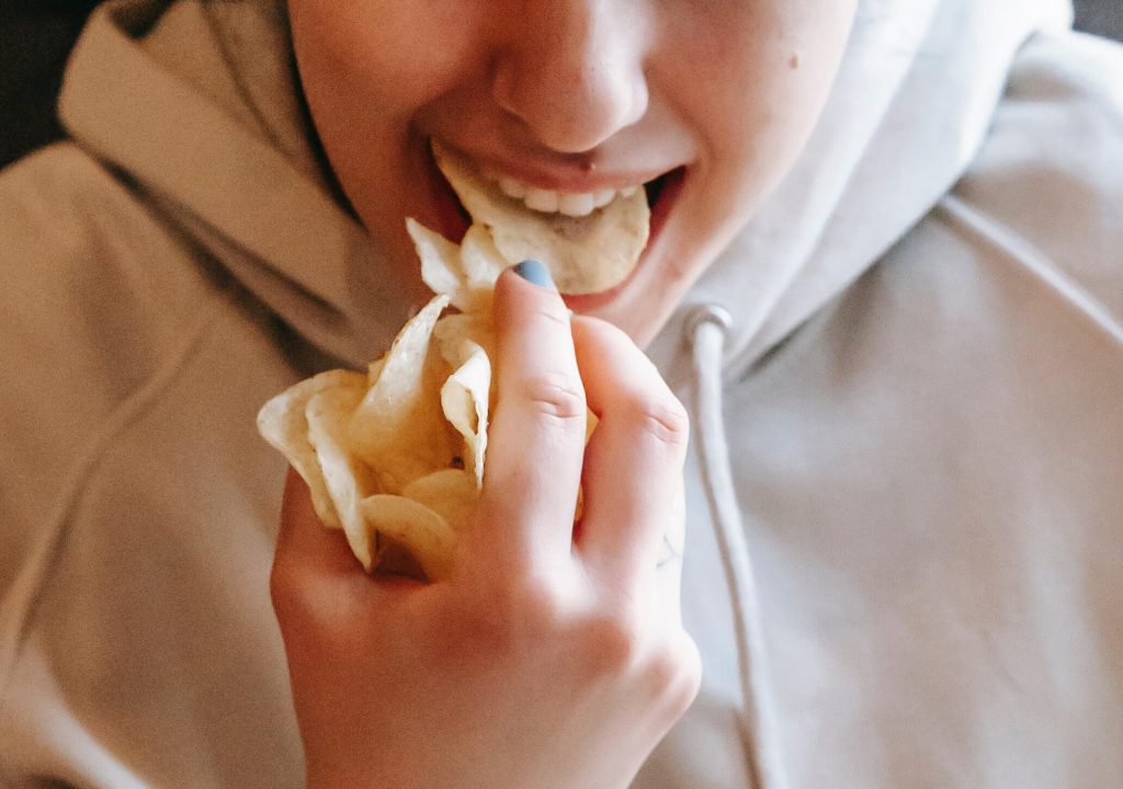 Woman eating potato crisps