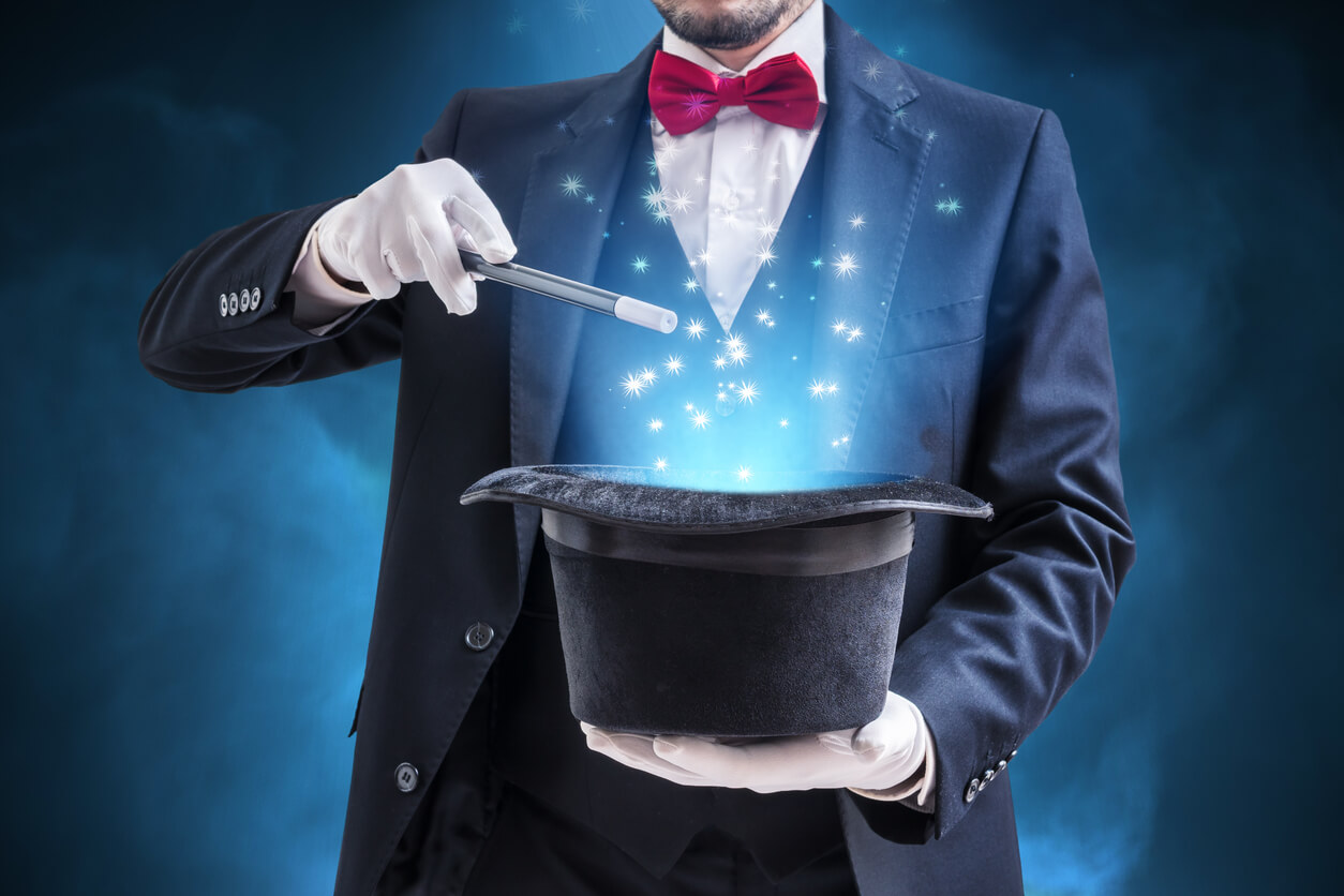 Magician-holding-wand-over-glowing-top-hat