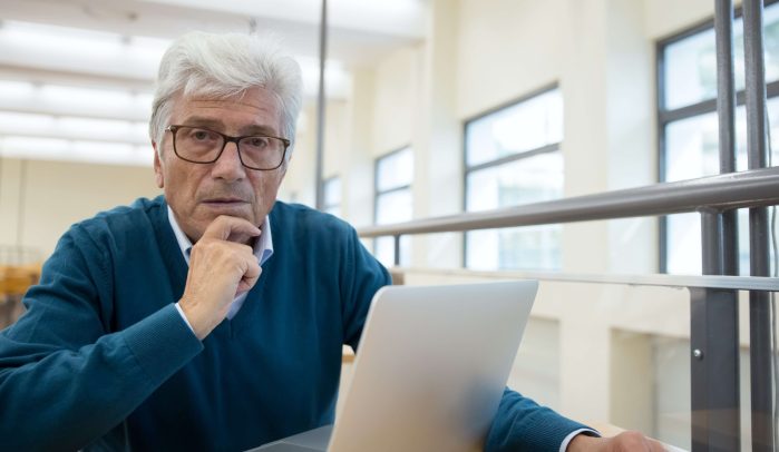 Confused looking older businessman at laptop