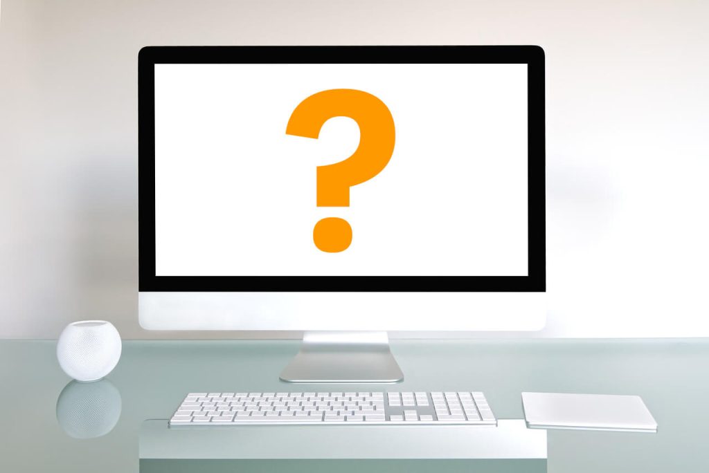 iMac-computer-on-a-desk-with-yellow-question-mark-on-white-screen.