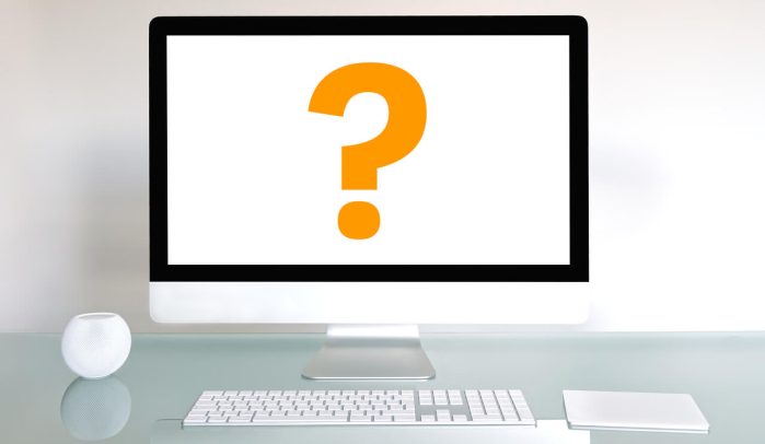 iMac-computer-on-a-desk-with-yellow-question-mark-on-white-screen.
