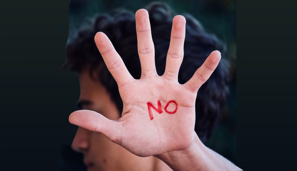 Man-holding-his-open-hand-towards-the-camera-the-word-NO-is-written-on-his-palm-in-red.
