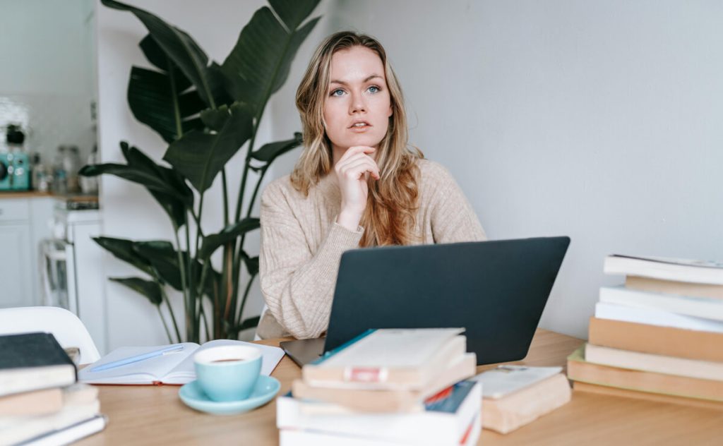 Young-blonde-woman-deep-in-thought-at-her-laptop