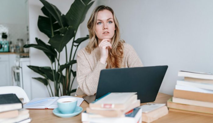 Young-blonde-woman-deep-in-thought-at-her-laptop